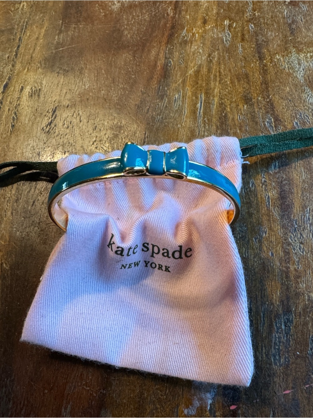 Kate Spade gold-tone blue/green bow bangle with pink pouch and green drawstrings